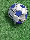 Auf grünem Rasen liegt ein kaputter Fußball. Darunter als Text "Foul Play"