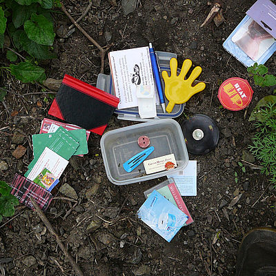 Auf Waldboden verteiltes Geo-Caching-Zubehör