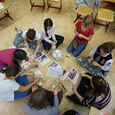 SchülerInnen in einem Sitzkreis bei einem Fußball-Workshop 